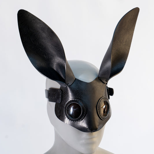 Bunny leather mask made by Atom Leather, from vegetable tanned leather, hot etched, on a mannequin head against a white background.
