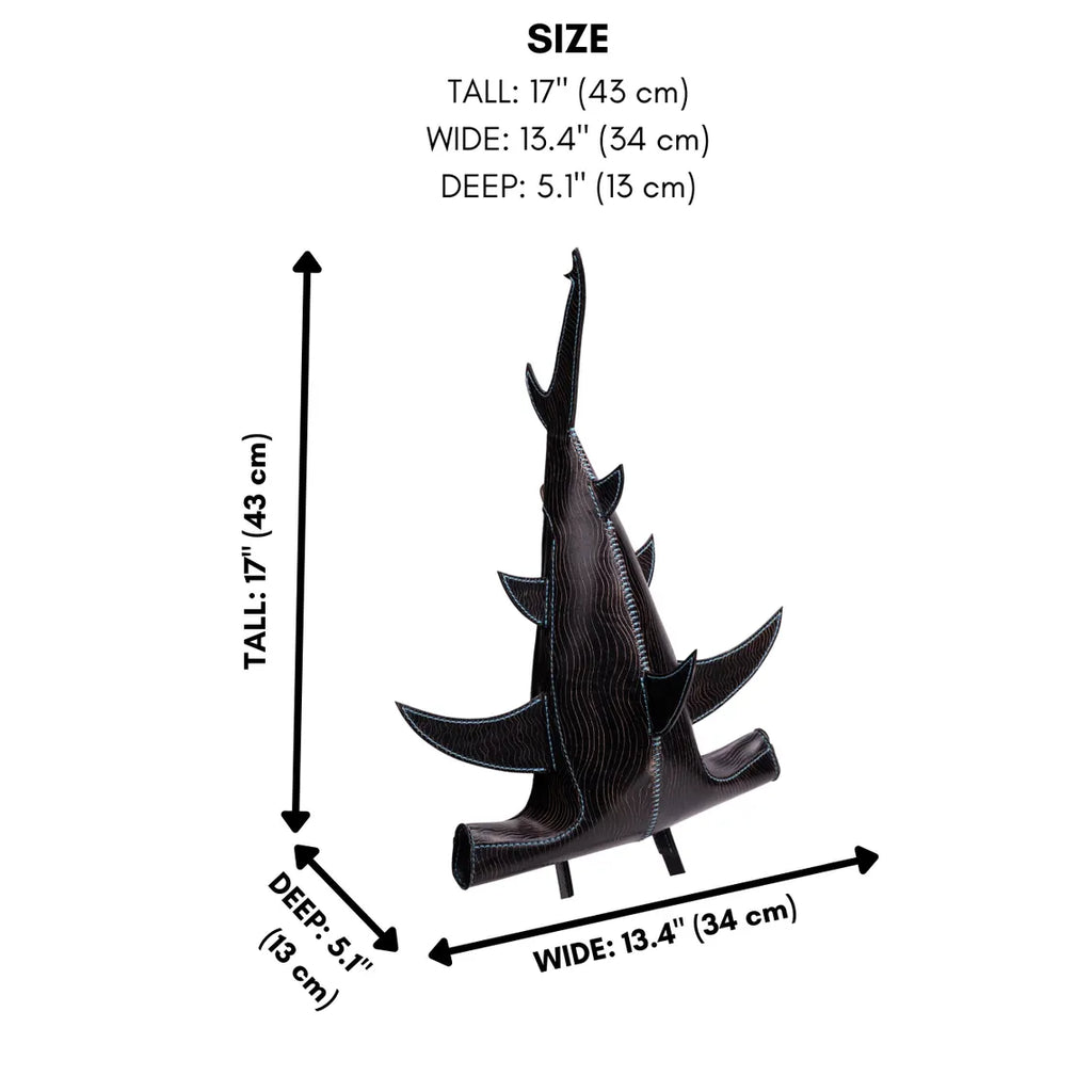 A black textured leather shark sculpture shown with dimension arrows and text indicating its size: tall 17 inches (43 cm), wide 13.4 inches (34 cm), and deep 5. Made by ATOM Leather.