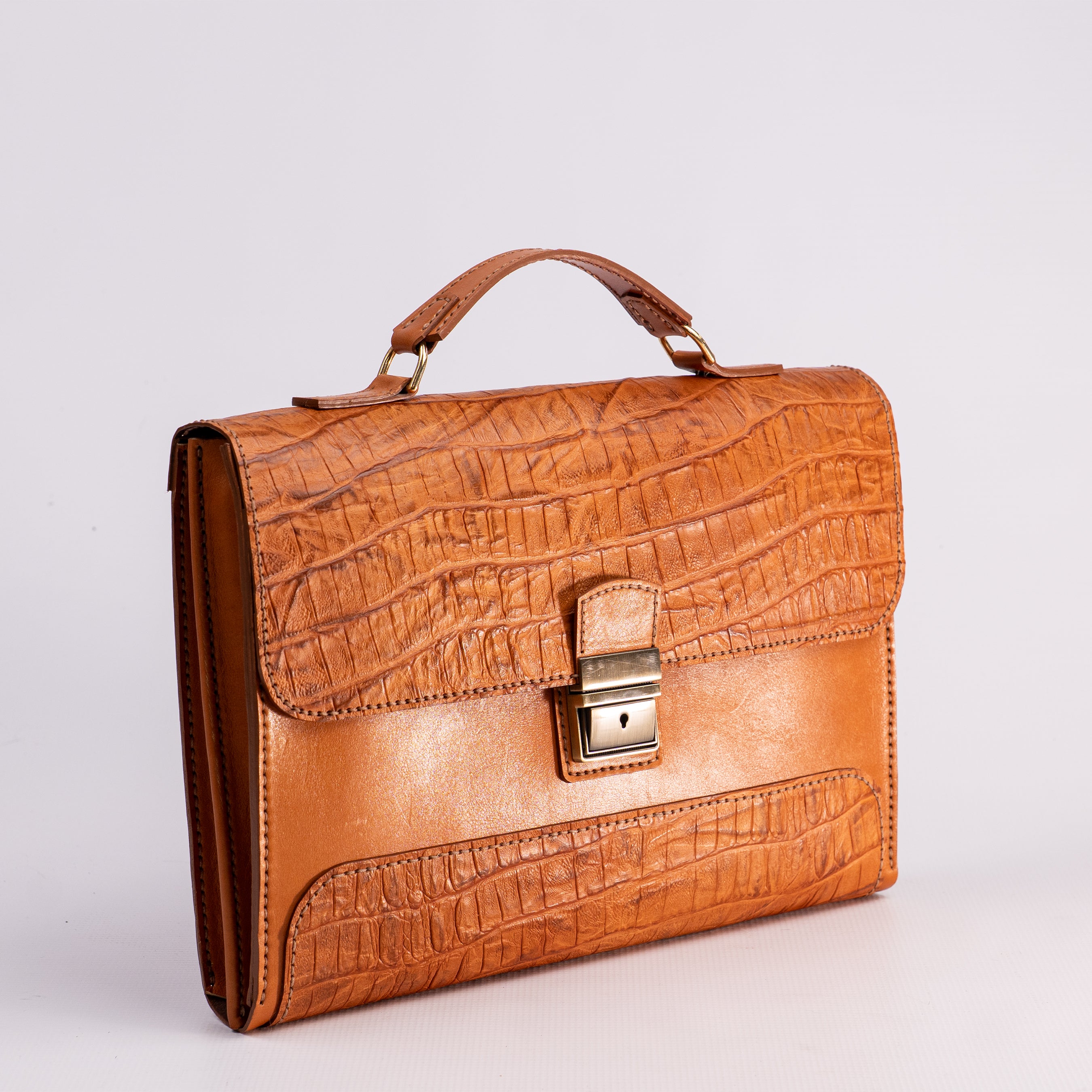 Brown crocodile-patterned leather briefcase on a light gray background