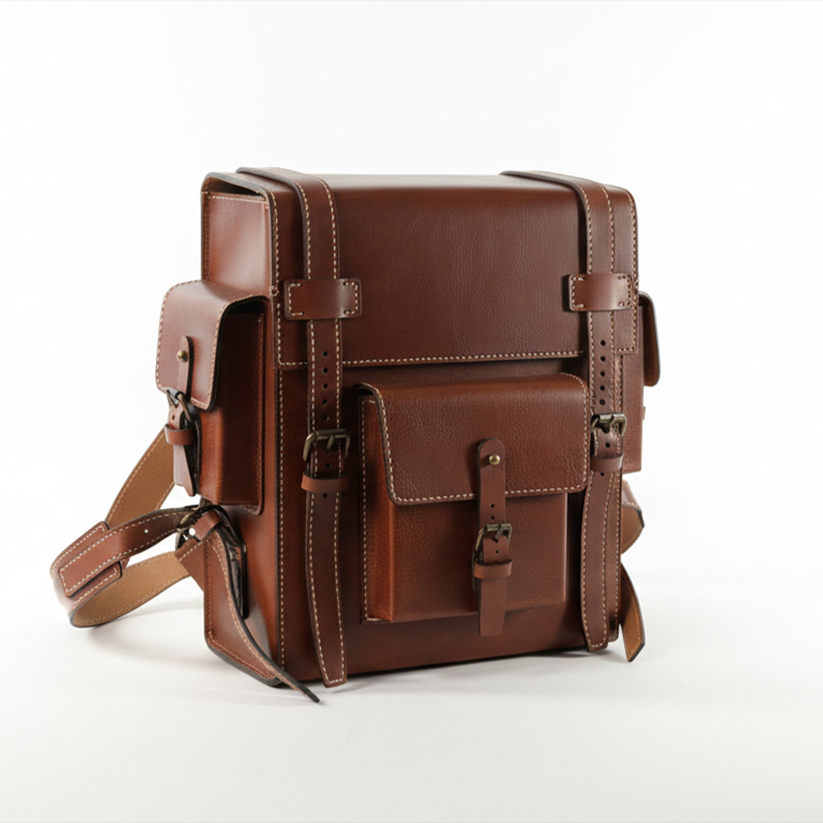 Brown leather backpack on a white background. Brown leather Toshiro backpack on a white background, designed and handcrafted by ATOM LEATHER.